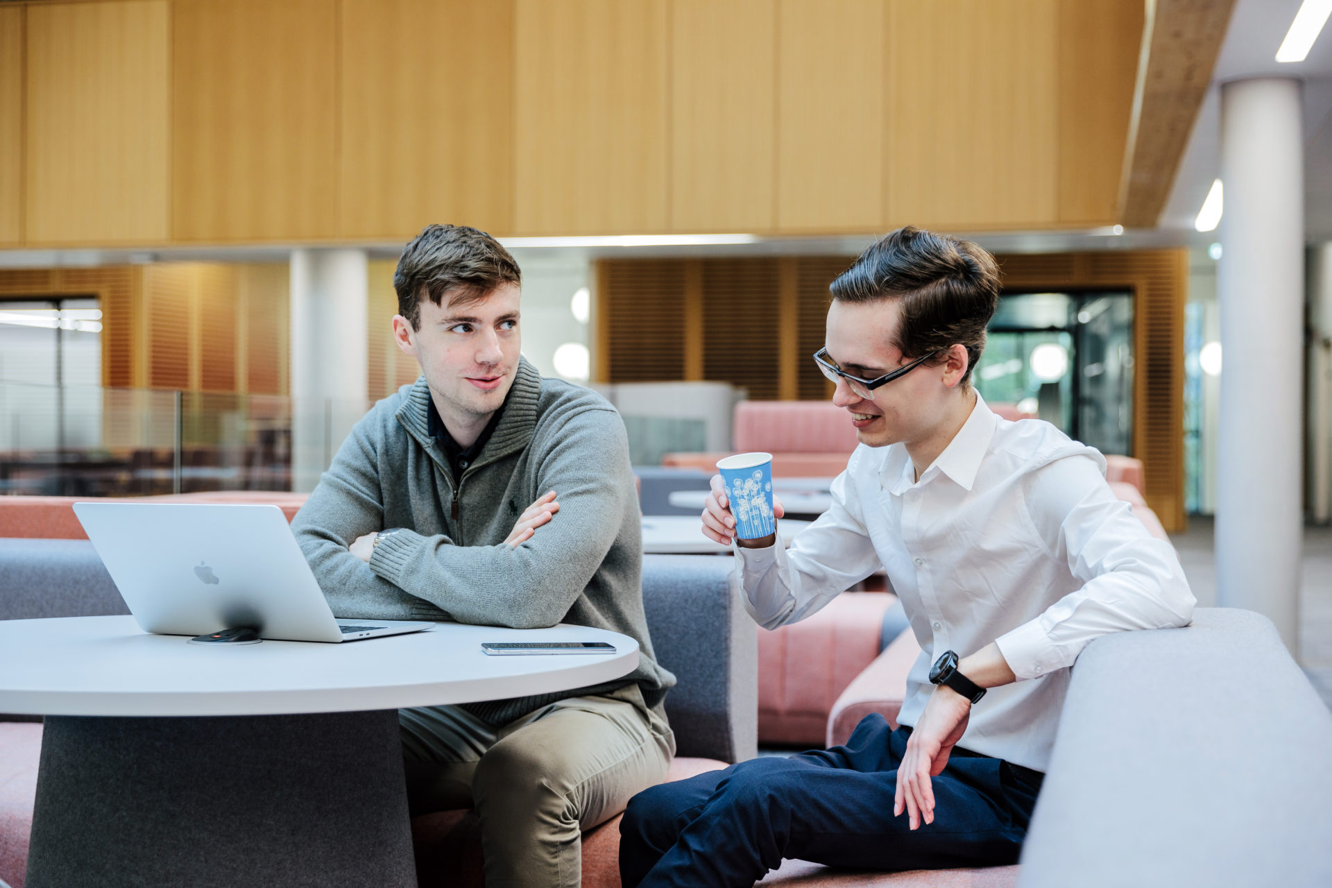 Two students work at a table with a laptop