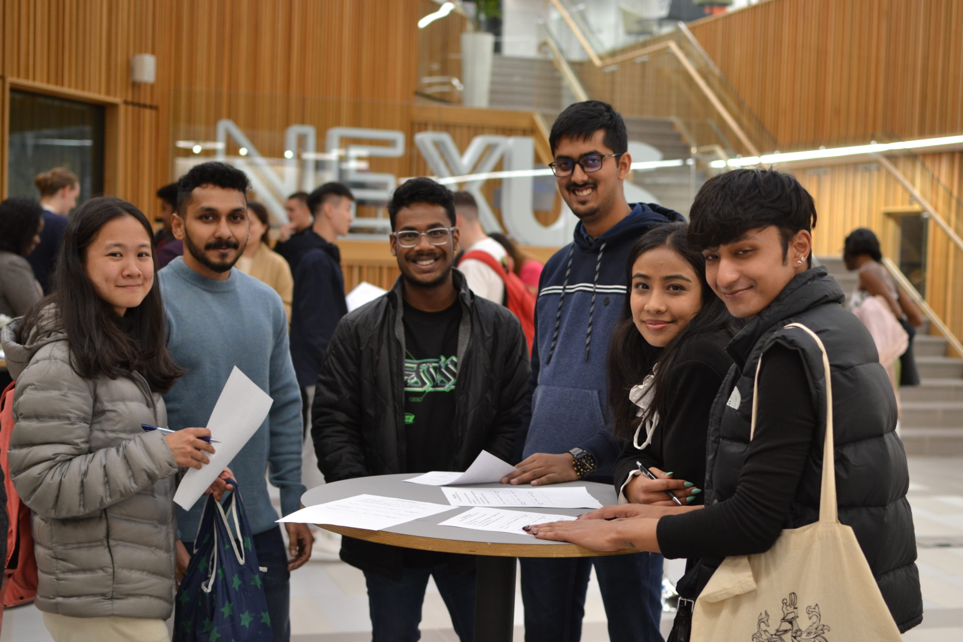 Students pose for a picture with their 'People Bingo' sheets